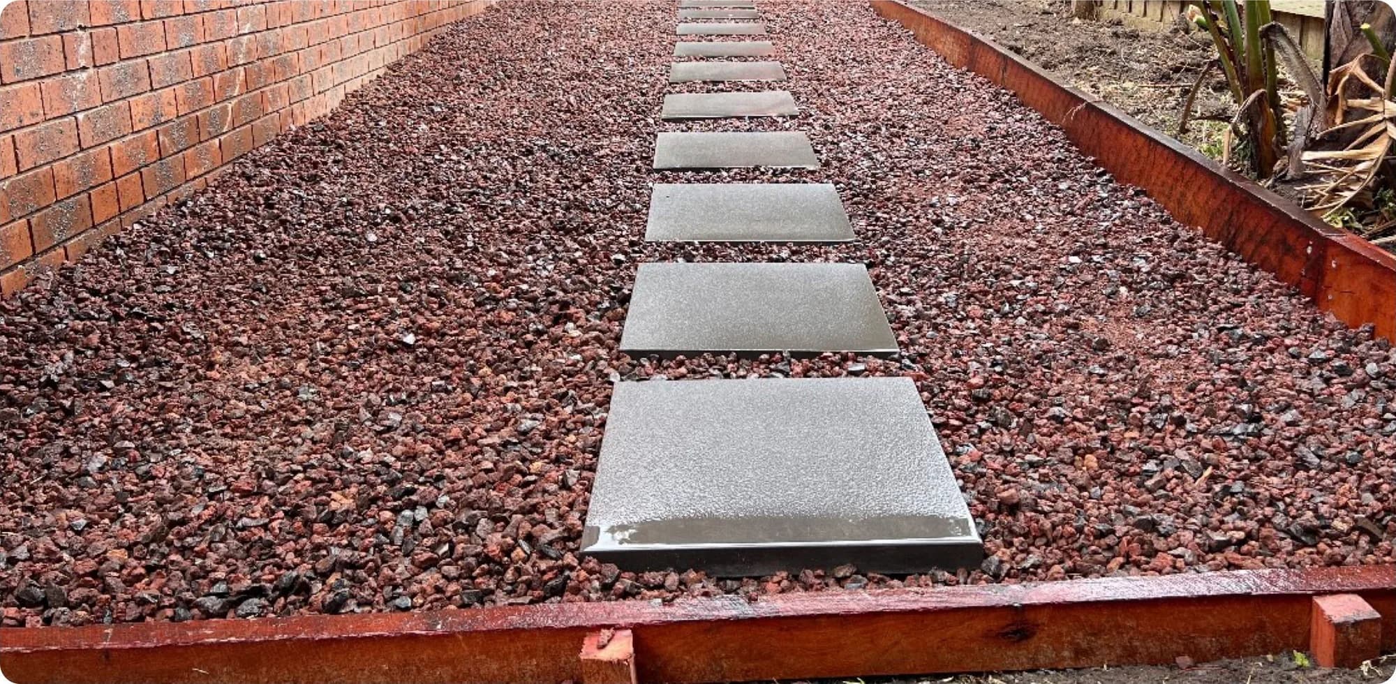 The same side path relaid with square stepping pavers set in red scoria
